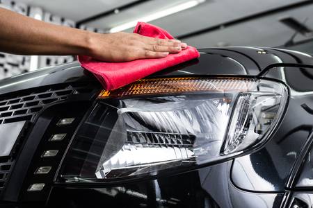 Car being cleaned with a red cloth
